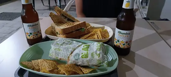 Mesa en la terraza de Umami Healthy Food con sándwiches, wrap y cervezas